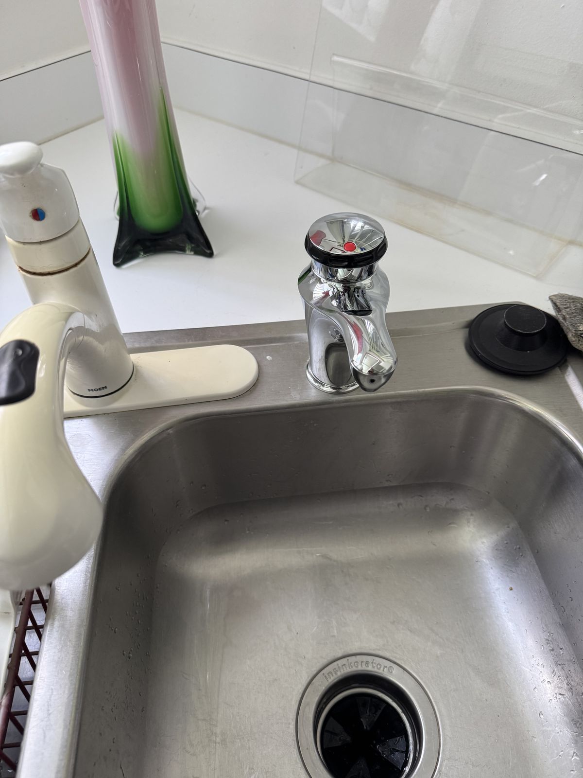 Chrome instant hot water dispenser installed at a stainless kitchen sink